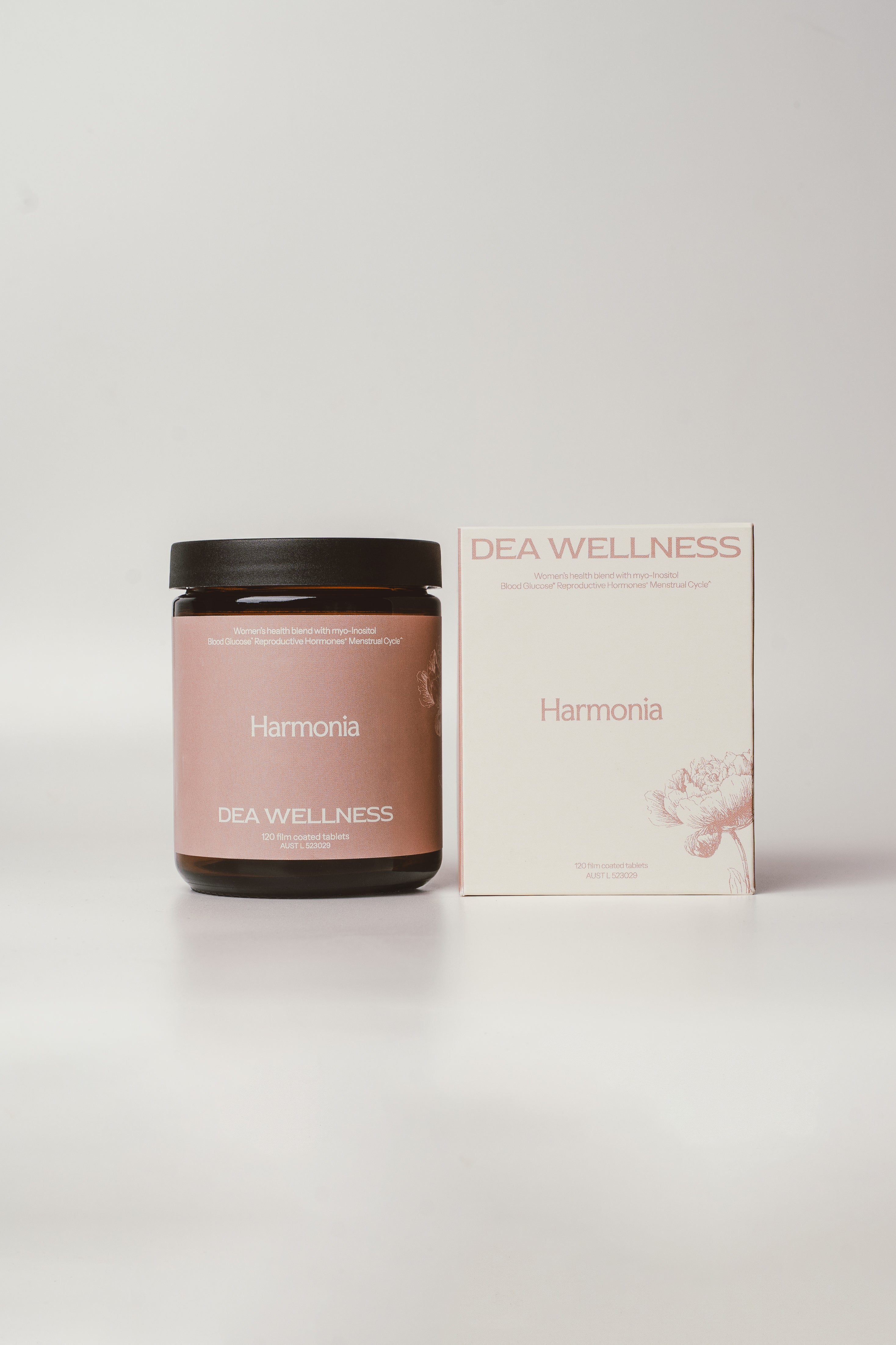 A dark amber glass jar  and its matching outer box from DEA Wellness, featuring a dusty rose label and packaging on a clean, light gray background. 